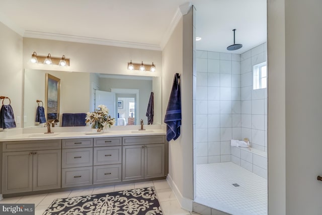 bathroom featuring tiled shower, tile patterned floors, ornamental molding, and vanity