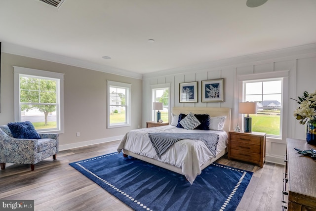 bedroom with hardwood / wood-style flooring and ornamental molding