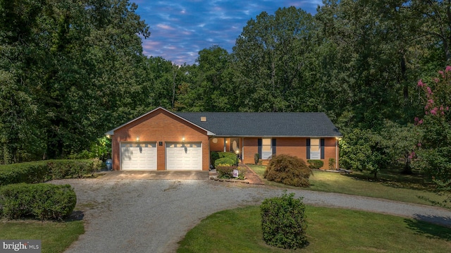 single story home featuring a lawn and a garage