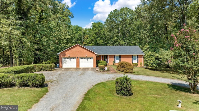 ranch-style home with a front yard, gravel driveway, brick siding, and an attached garage