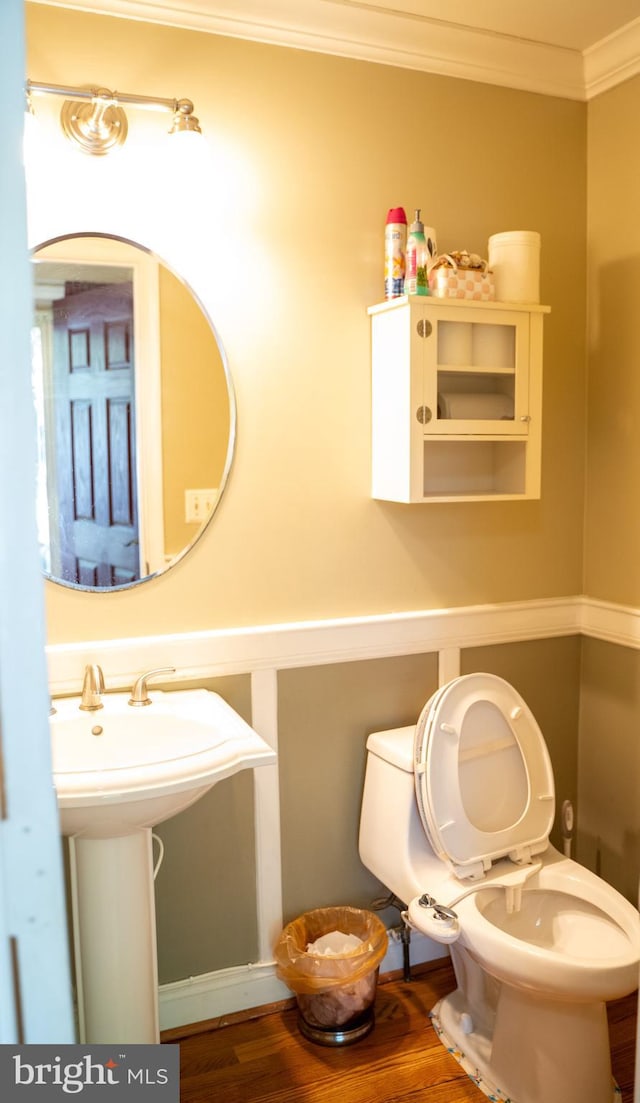 bathroom featuring hardwood / wood-style floors, sink, toilet, and crown molding