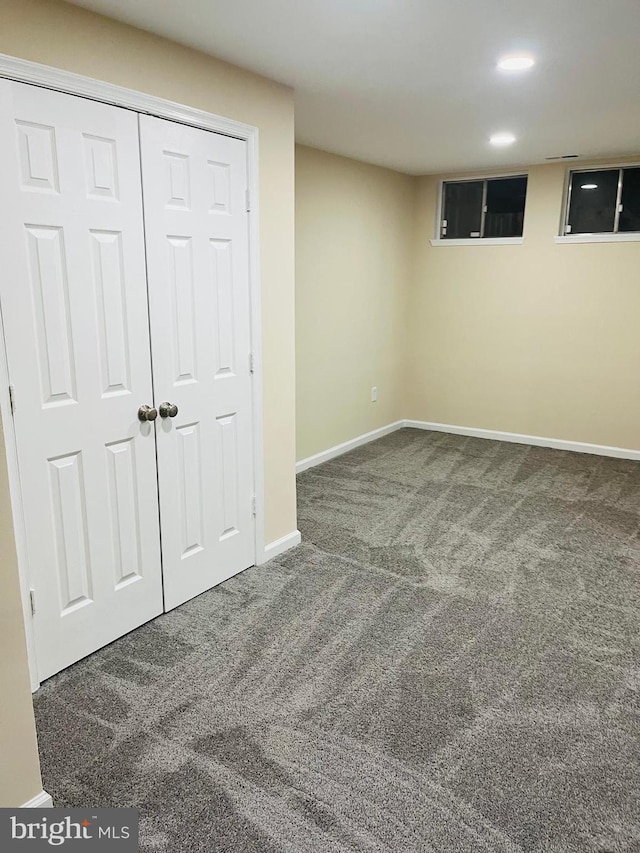 basement with dark colored carpet