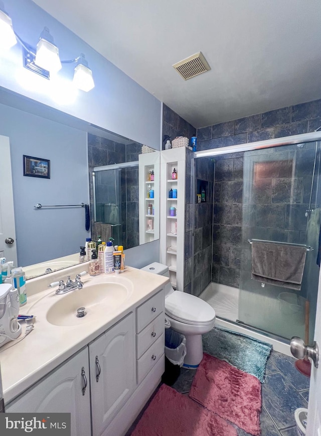 bathroom with toilet, vanity, and walk in shower