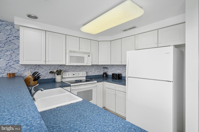 kitchen with white appliances, backsplash, white cabinetry, and sink