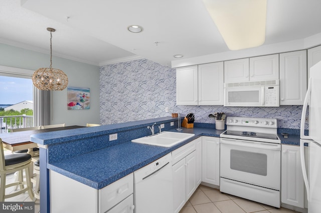 kitchen featuring white appliances, kitchen peninsula, sink, and backsplash