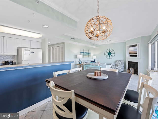 tiled dining room featuring a fireplace and crown molding