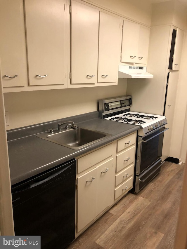 kitchen featuring light wood-type flooring, wall chimney exhaust hood, black dishwasher, sink, and white gas range oven