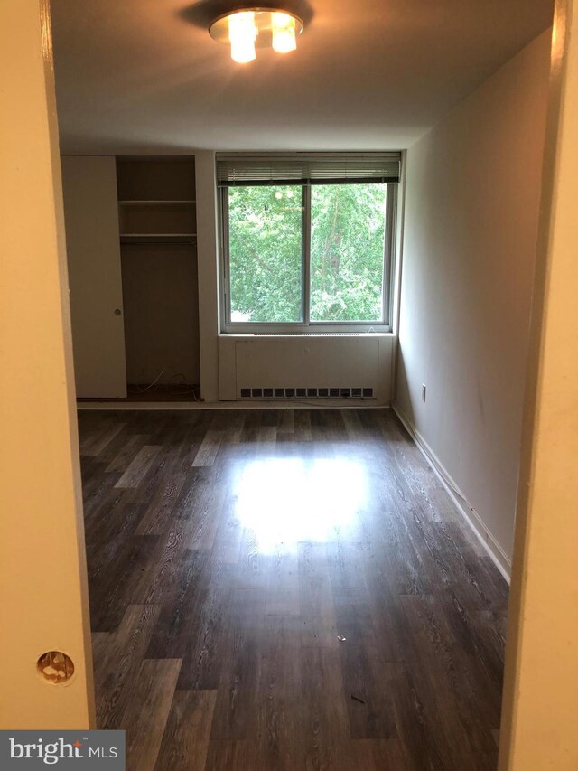 spare room featuring dark wood-type flooring