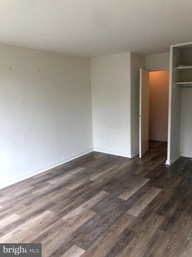 unfurnished bedroom with a closet and dark wood-type flooring