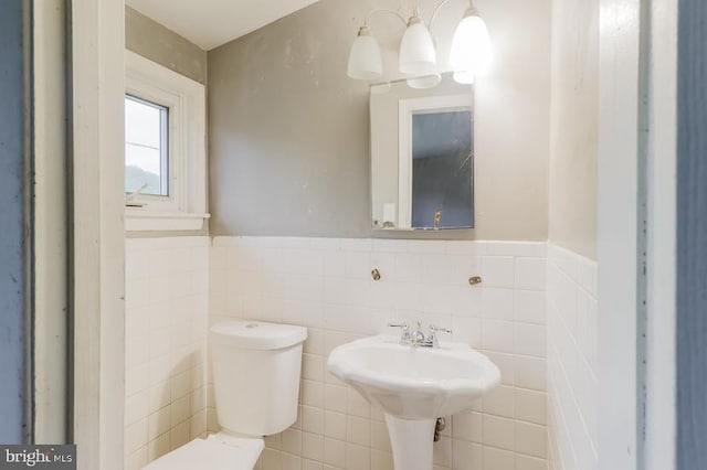 bathroom featuring tile walls and toilet