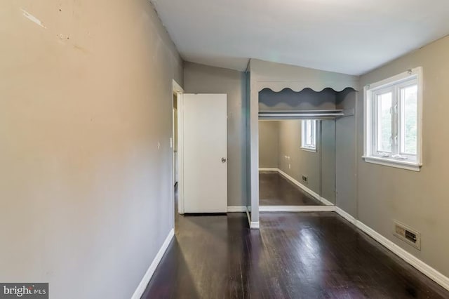 unfurnished bedroom with lofted ceiling and dark hardwood / wood-style flooring