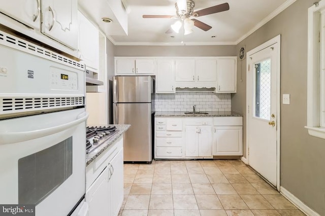 kitchen featuring light tile patterned floors, stainless steel appliances, ornamental molding, and white cabinetry