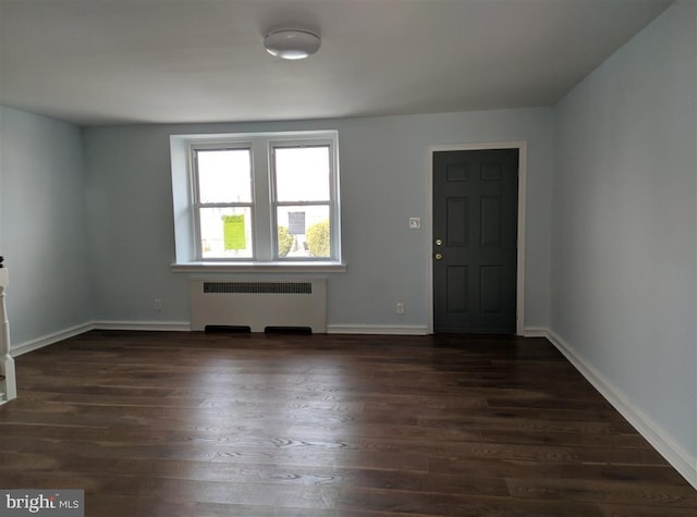 entrance foyer with dark hardwood / wood-style floors and radiator