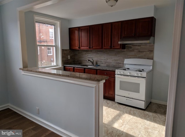 kitchen with tasteful backsplash, light hardwood / wood-style floors, sink, kitchen peninsula, and white range with gas cooktop