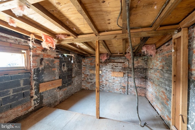 basement featuring brick wall