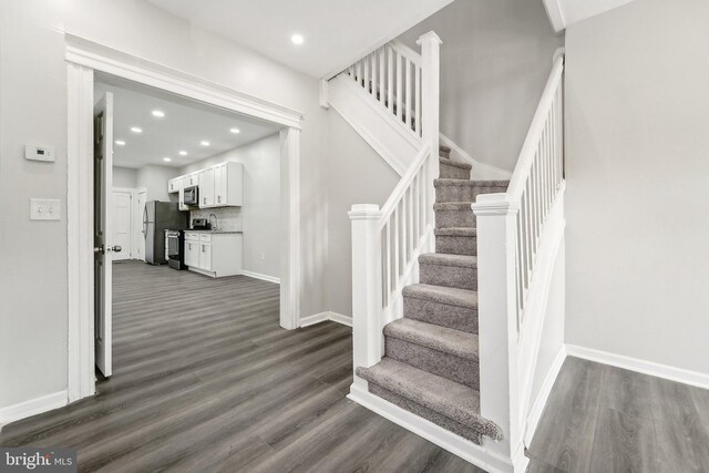 stairs featuring hardwood / wood-style floors