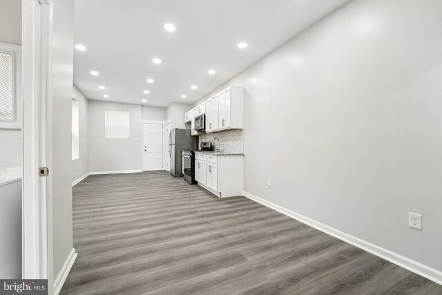 unfurnished living room with hardwood / wood-style floors and sink