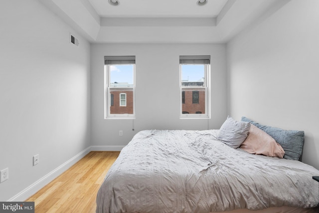 bedroom featuring a raised ceiling and hardwood / wood-style floors