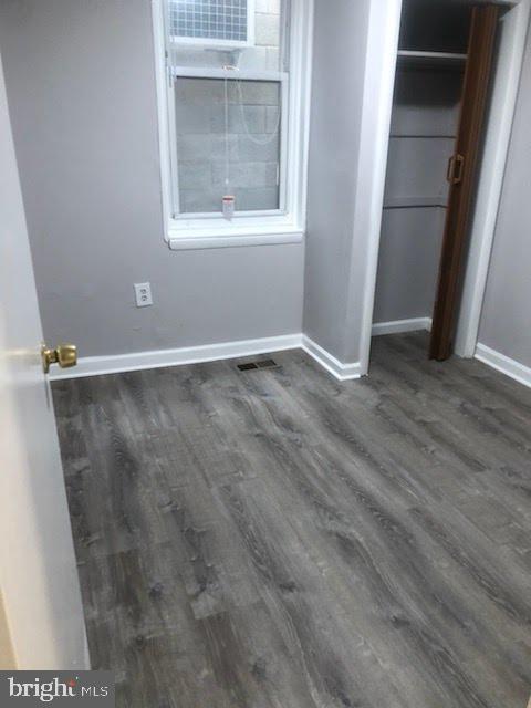 unfurnished bedroom with a closet and dark hardwood / wood-style floors