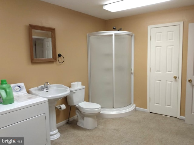 full bathroom with a shower stall, washer / dryer, and baseboards