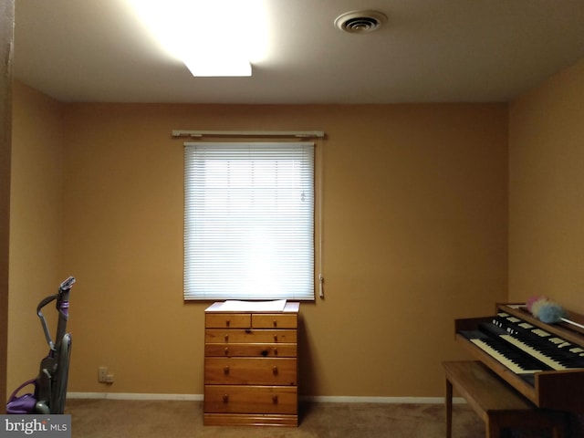 miscellaneous room with baseboards, visible vents, and light colored carpet