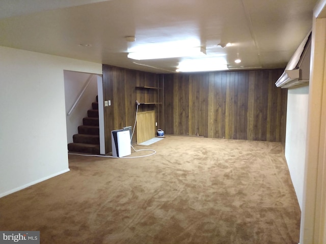 finished basement with stairs, carpet floors, and wooden walls