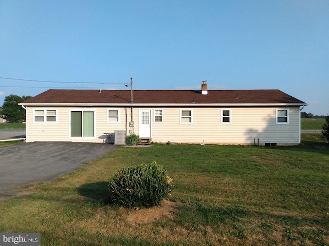 back of property with entry steps, a yard, a chimney, and cooling unit