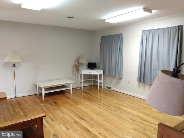 office area featuring baseboards, visible vents, and wood finished floors