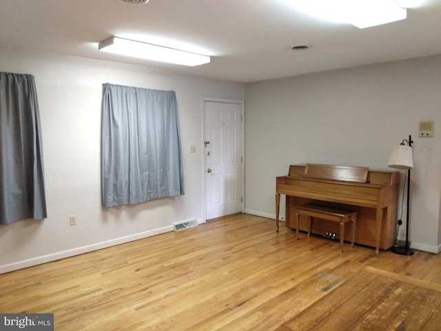 sitting room with visible vents, baseboards, and wood finished floors