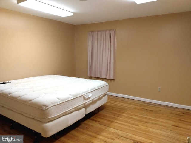 bedroom featuring wood finished floors and baseboards