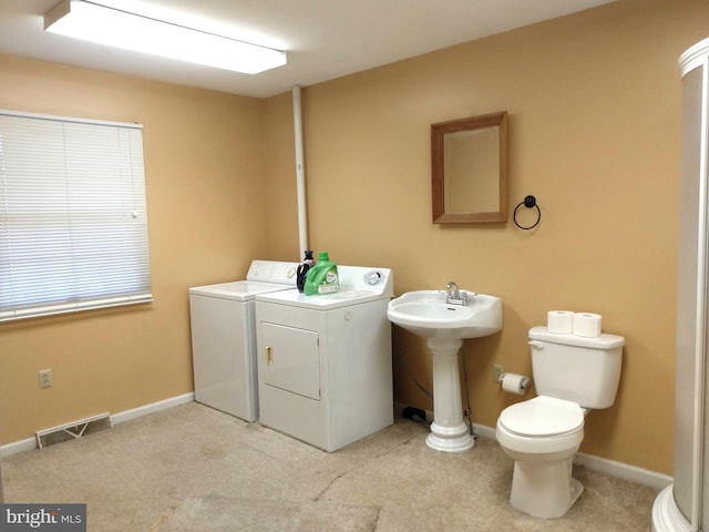 laundry area featuring laundry area, washing machine and dryer, visible vents, and baseboards