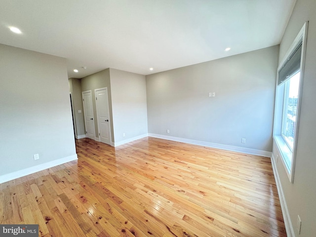 empty room with recessed lighting, baseboards, and light wood finished floors