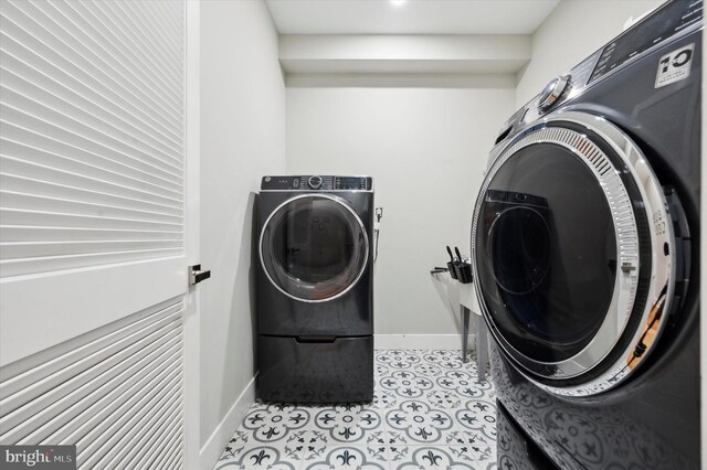 clothes washing area with separate washer and dryer and light tile patterned floors