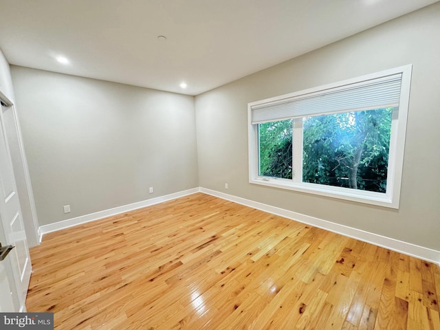 empty room featuring light wood-style floors, recessed lighting, and baseboards