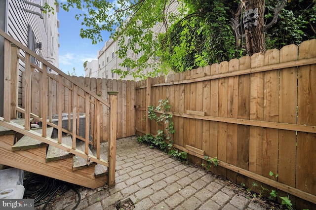 view of patio featuring cooling unit and fence