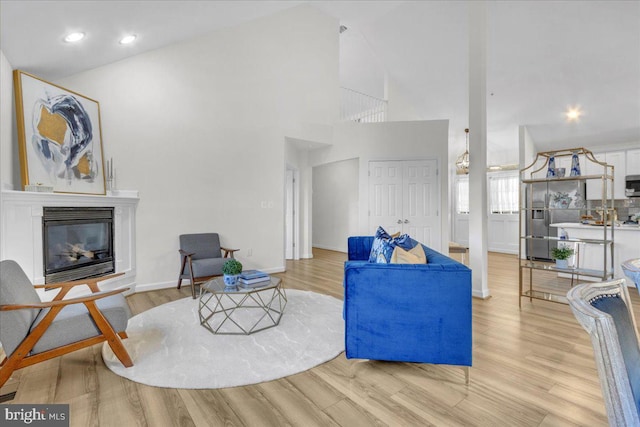 living room featuring light hardwood / wood-style floors and high vaulted ceiling