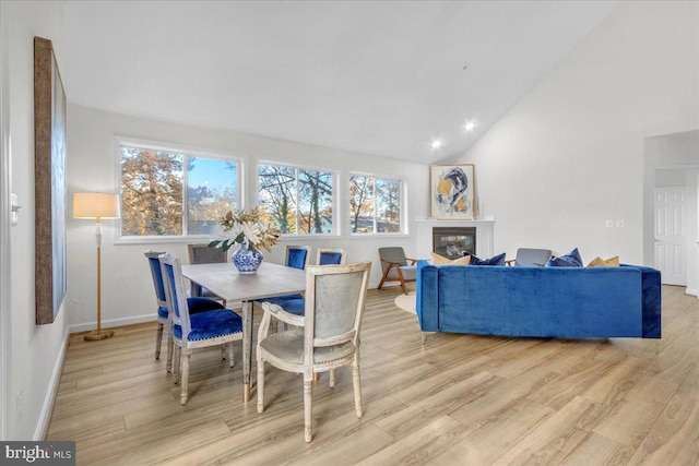 dining space featuring light hardwood / wood-style floors and lofted ceiling