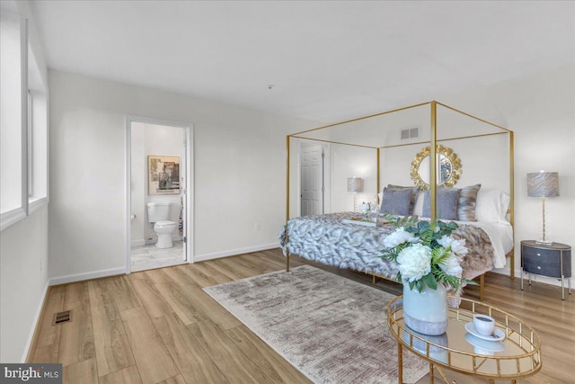 bedroom featuring light hardwood / wood-style floors and ensuite bathroom