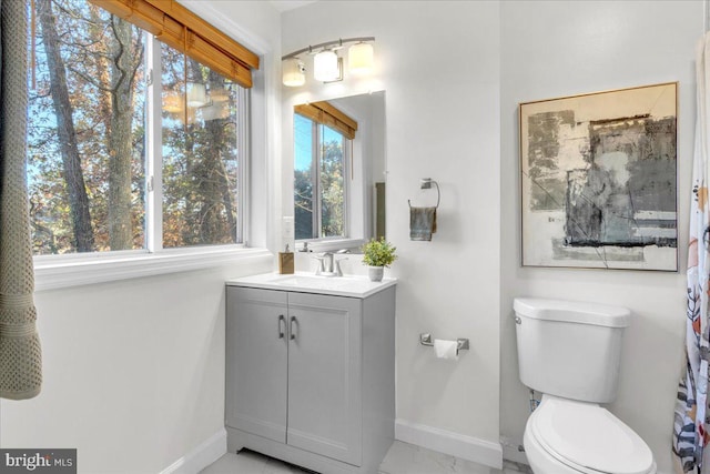 bathroom with vanity, a healthy amount of sunlight, and toilet