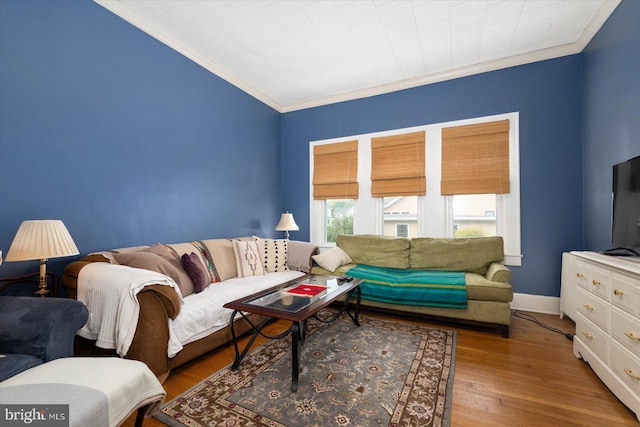 living area with ornamental molding, baseboards, and wood finished floors