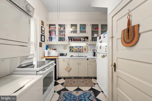 kitchen featuring white cabinets, glass insert cabinets, light countertops, and tile patterned floors