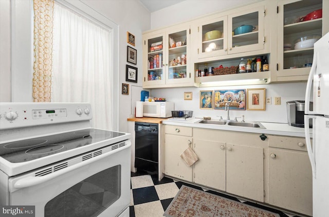 kitchen featuring light countertops, white appliances, dark floors, and glass insert cabinets