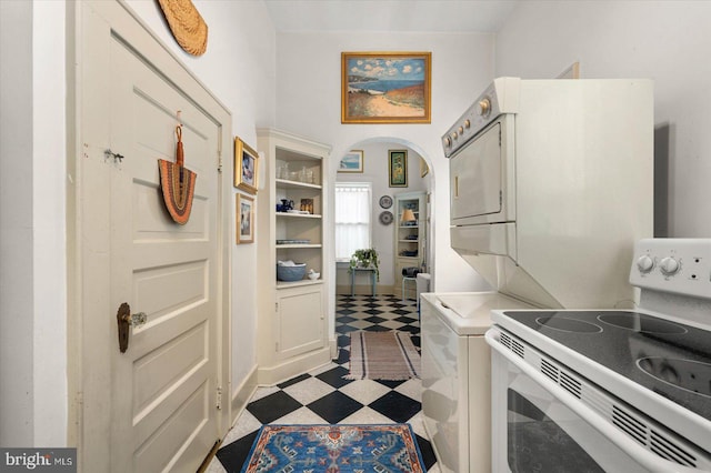 kitchen with arched walkways, light floors, white electric range oven, light countertops, and white cabinetry