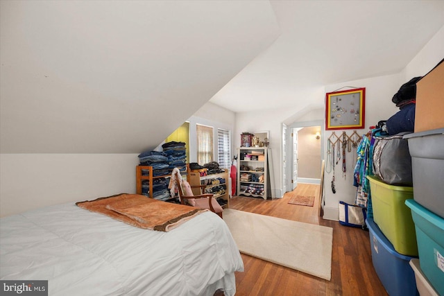 bedroom with lofted ceiling and wood finished floors