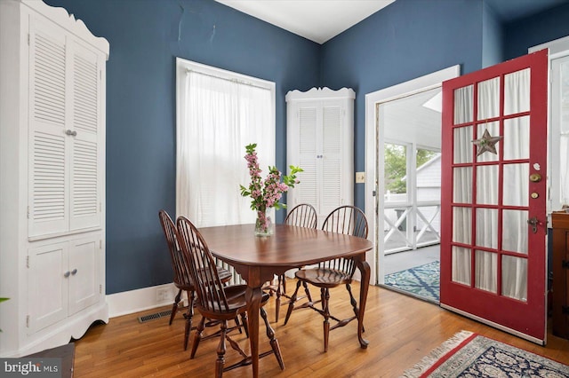 dining area featuring baseboards, visible vents, and wood finished floors