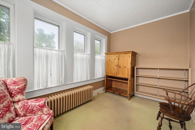 sitting room featuring radiator, baseboards, crown molding, and light colored carpet