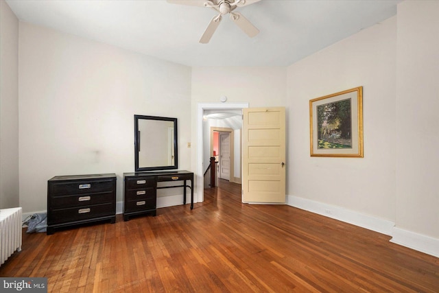 bedroom with radiator, dark wood-style floors, ceiling fan, and baseboards