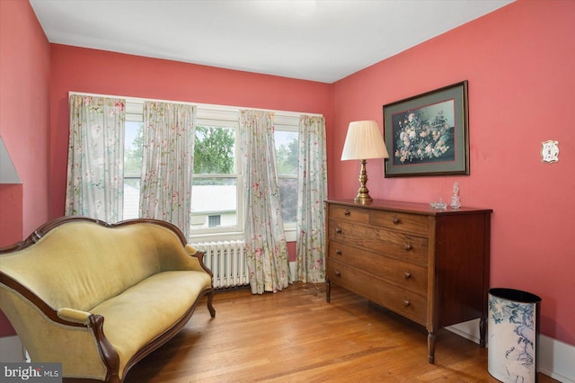 sitting room featuring radiator and light wood-style floors