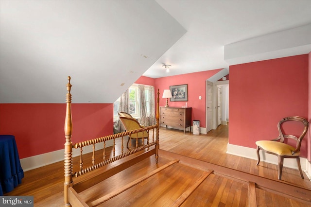 interior space with lofted ceiling, baseboards, and wood finished floors