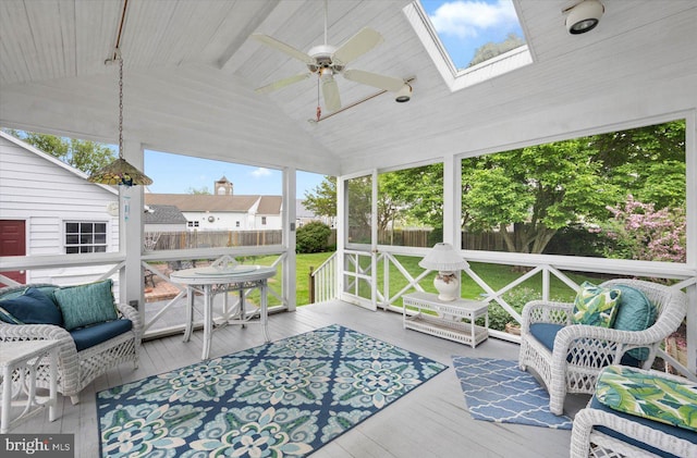 sunroom featuring a ceiling fan and vaulted ceiling with skylight